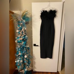 Comfortable bandage fabric, strapless design and feather accents.